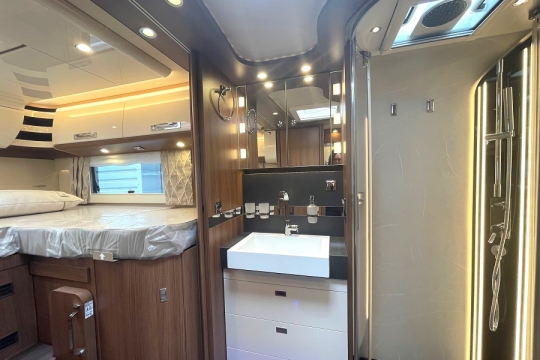 carthago-e-line-i-61-xl-le-interior-bathroom-to-bed.jpg